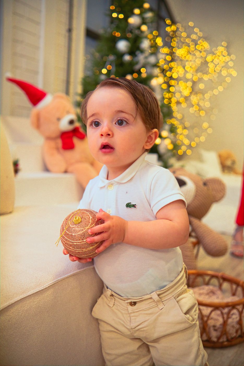 Bebê segurando uma bola de Natal