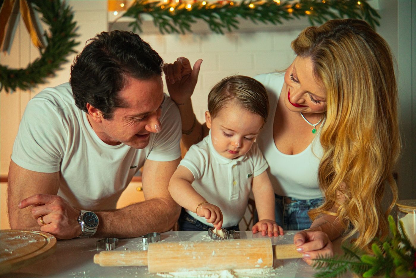 Família abrindo massa de biscoito na cozinha